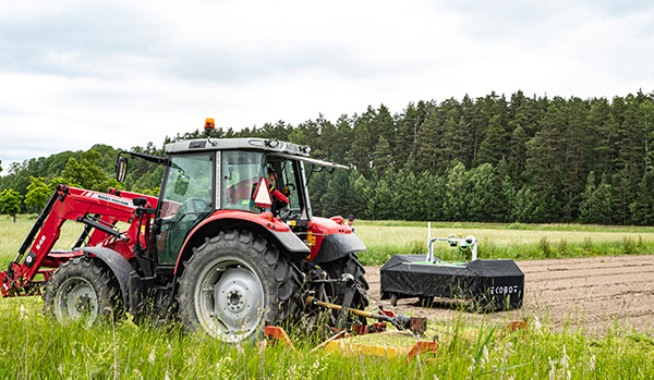 Rød traktor ute på åkeren.